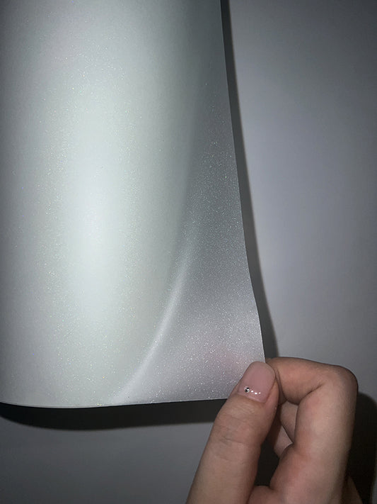Close-up of glitter DTF film texture as a sheet corner is peeled back